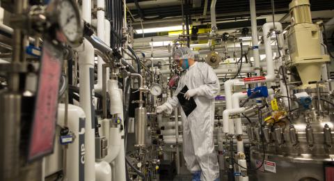 Chemical engineer in safety gear working in facility 