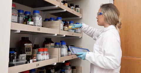 UNHCEMS researcher organizing lab materials on a shelf